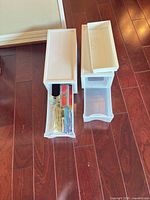 Two white Sterilite drawer units with lids shown side by side on floor