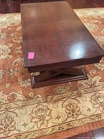 Top view of rectangular dark cherry coffee table on rug