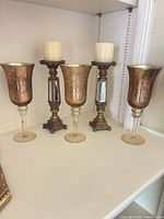 Front view of three goblets and candlesticks together