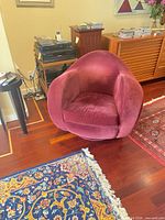 Front view of burgundy velvet swivel chair with cushion