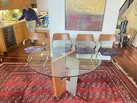 Glass top dining table with four chairs shown together