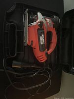 Jigsaw inside open plastic case showing cord and blade area