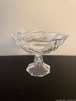 Side view of pressed glass compote showing pedestal and ruffled rim
