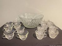 Punch bowl, ladle, twelve cups displayed