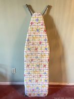 ironing board standing folded, cover visible