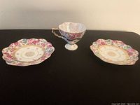 Teacup and two matching scalloped saucers displayed