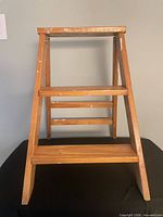 Front view of stool opened showing two steps and top platform