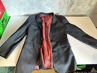 Full front view of Bellissimo wool blazer laid flat, showing exterior, buttons, pockets, lapels