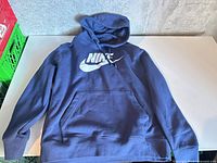 Full view of blue Nike pullover hoodie laid flat