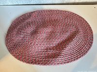 Top view of the colourful braided placemat showing full oval shape and weave detail