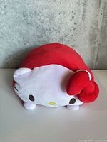 Front view of red and white Hello Kitty plush with bow
