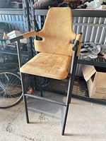 Front view showing full black metal frame, tan upholstered seat and backrest