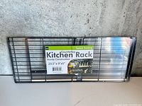 Full view of packaged black wire countertop rack with label