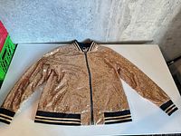 full view of gold sequin bomber jacket laid flat