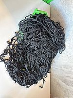 bundled black rope soccer net on white surface