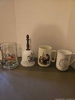 Group view of three mugs and bell