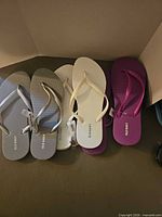 Three pairs of Old Navy flip flops grey, white, purple