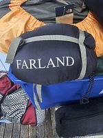 Sleeping bag in compression sack showing Farland logo