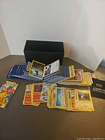 Overview of cards spread out in front of black storage box