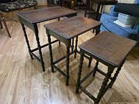 Three nesting tables displayed side by side showing tops and legs