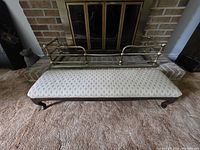 Full view of bench and brass fender in front of fireplace