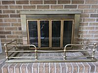 Full view of brass fireplace fender in front of fireplace