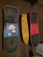 Three skateboards laid flat showing deck colors and grip areas
