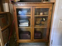 Front view of oak display cabinet showing double glass doors and shelves
