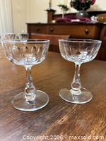 Both antique cut crystal champagne coupes showing thumbprint facets and baluster stems