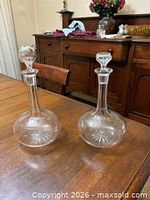 Pair of clear etched glass decanters with starburst pattern and stoppers