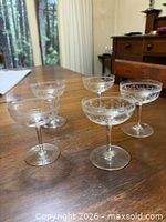 Five matching Art Deco crystal champagne coupe glasses on table