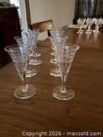 Eight matching crystal cordial glasses on table