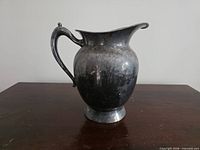 Right-side view of tarnished silver-plated pitcher showing overall form and patina
