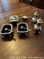 Group shot showing all silver-plated condiment pieces with cobalt liners and spoons