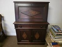Front view of closed secretary desk showing overall form and veneer panels