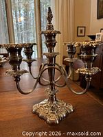 Front view of ornate silver plated five-arm candelabra on tabletop