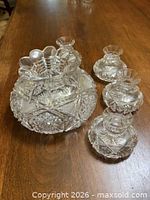 Cut glass centerpiece bowl with three matching candle holders on wooden surface