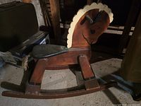 full view of handmade wooden rocking horse showing color, form and wear