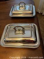 Both silver-plated covered serving dishes shown with lids in place, displaying beaded rims and handles