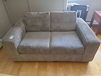 Front view of gray corduroy loveseat showing cushions and upholstery