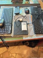 Keyboards, mice, tablet cover, phone case displayed on desk