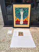 Framed textile art with accompanying artist information sheet