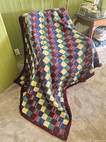 Multicolor patchwork quilt draped to show pattern and size