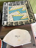 Top view of platter and underside of boat dish showing signature and shape