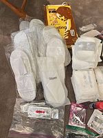 Overview of slippers, heating pad box, toiletry pouches and toothpaste