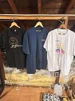 Front view of all three t-shirts hanging