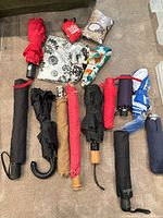 All umbrellas and pouches laid out showing styles, colours and handles