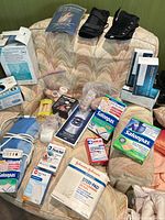 Overall view showing heating pad, Salonpas boxes, Steri-Pad box, bandages, braces, wraps, respirator masks