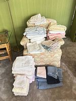 Overall lot showing folded towels and sheets on chair and floor