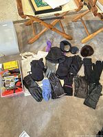 Assorted gloves, mittens, hats and ear accessories laid out on floor